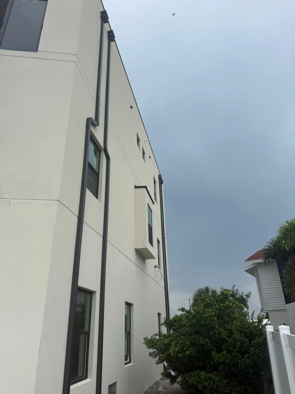 Black seamless gutters installed on a multi-story commercial building in Tampa Bay