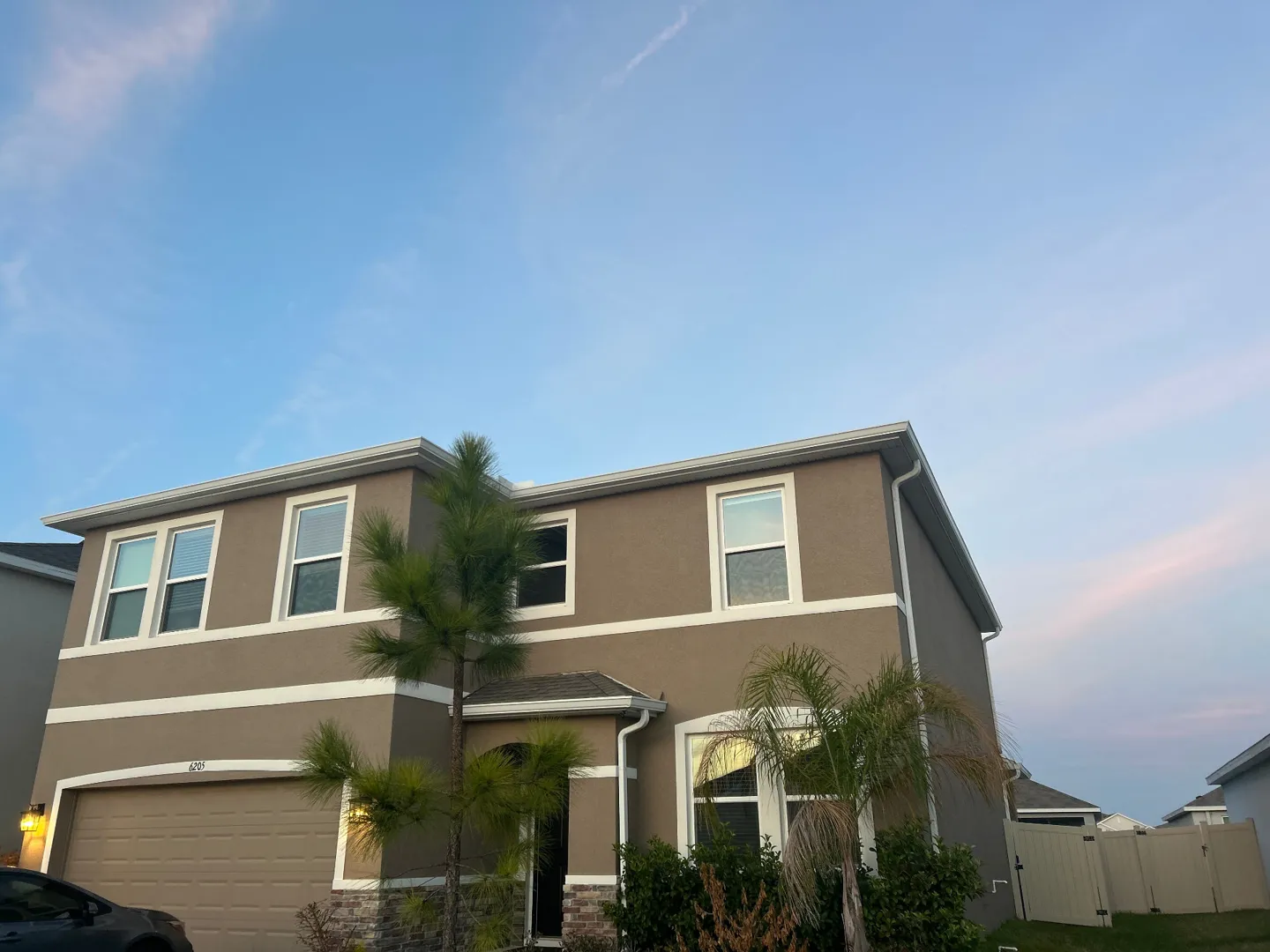 Custom-color seamless gutters and downspouts on the front of a two-story Dade City FL home