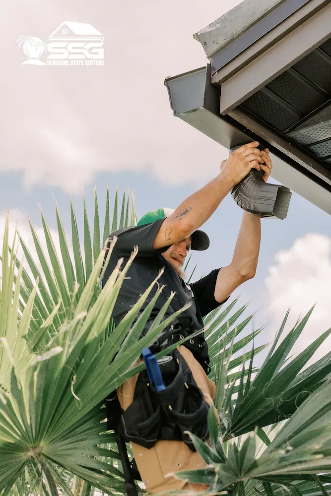 Installer mounting a 7-inch seamless gutter along the fascia of a Florida home
