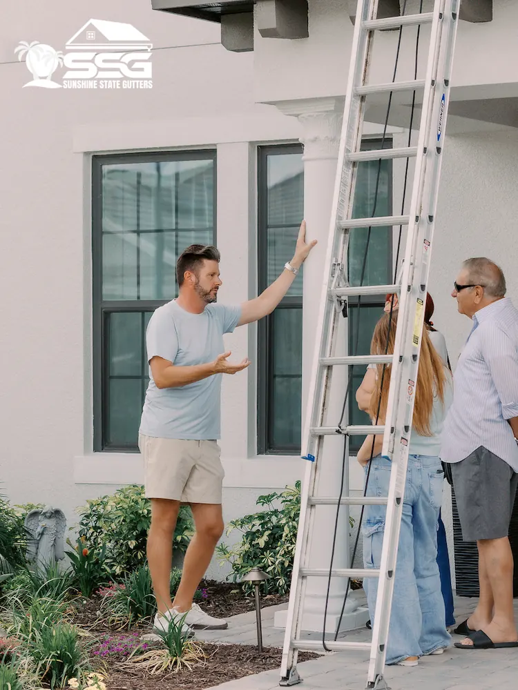 Owner of Sunshine State Gutters discussing a gutter installation project with homeowners outside a Tampa, Florida residence.